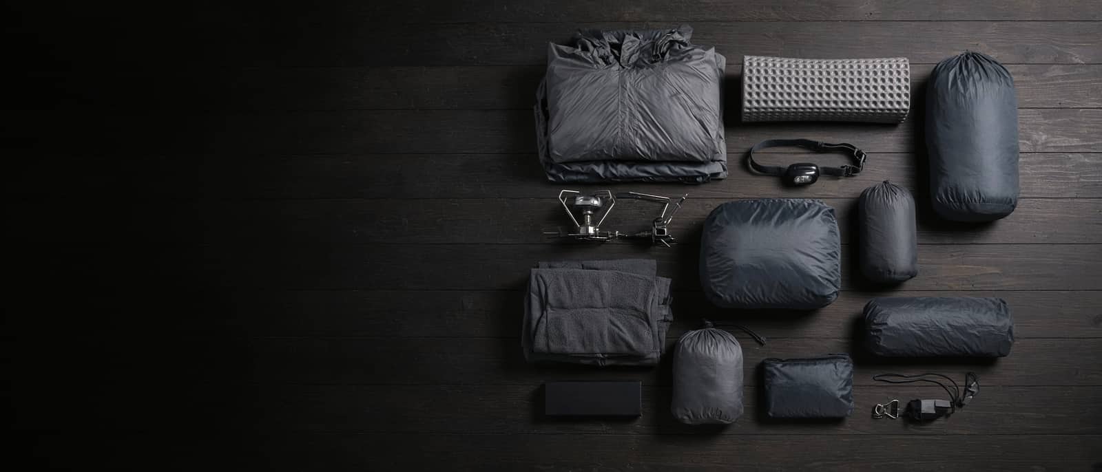 A dense grid of gear on a dark wood floor shot from above
