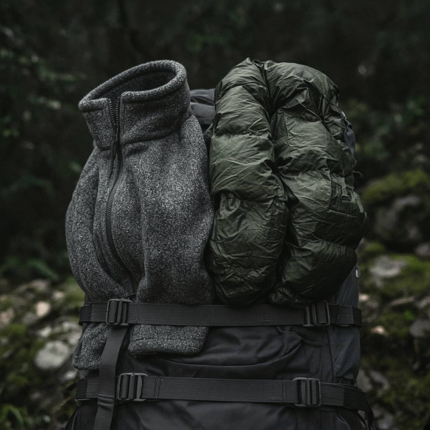 A fleece and a puffy hung side by side on a pack