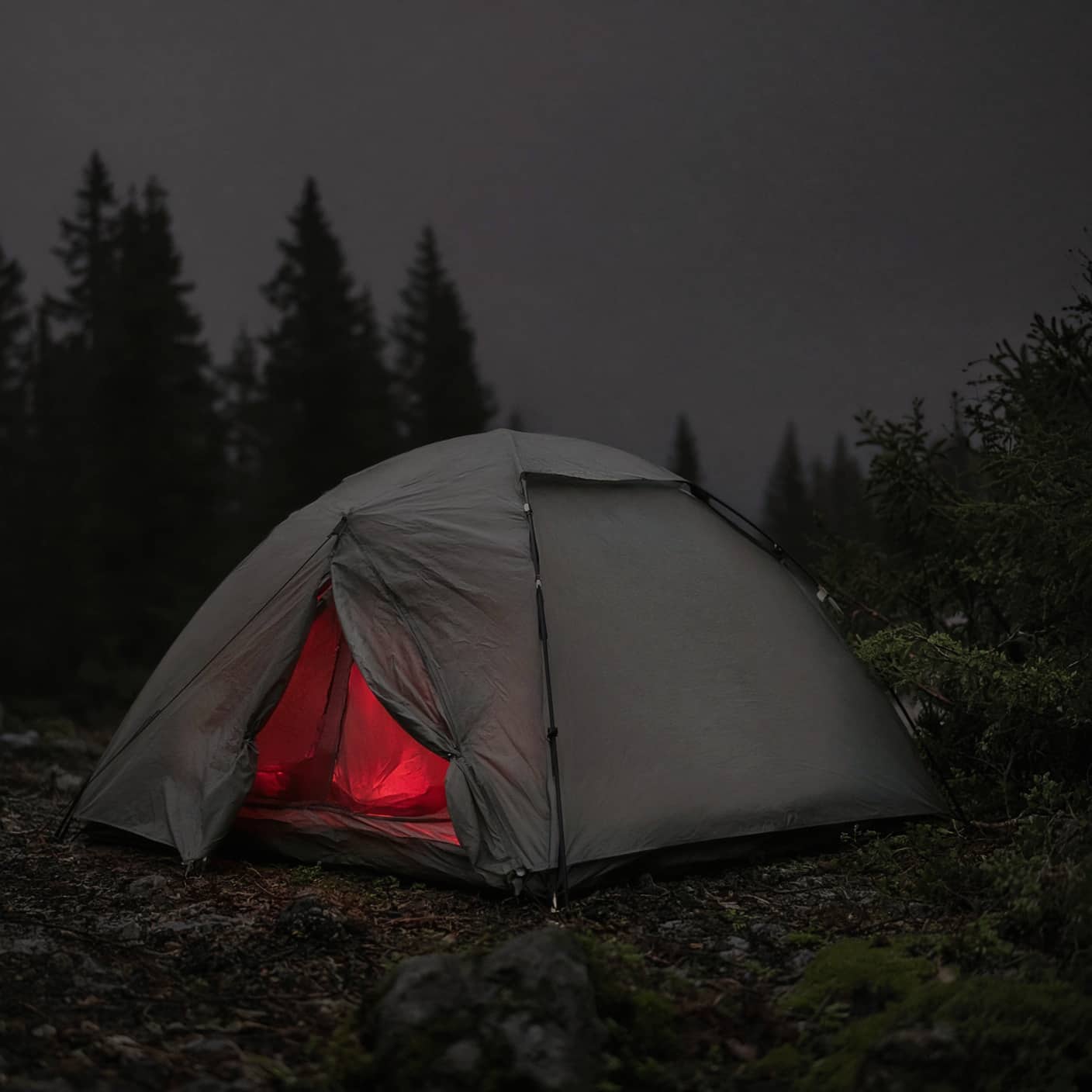 A low red light glowing inside a tent at night
