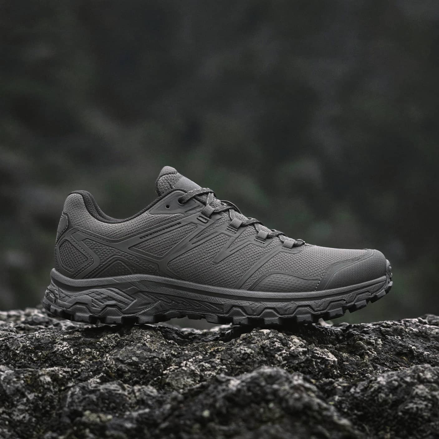 Side profile of a trail shoe on a rock, low angle