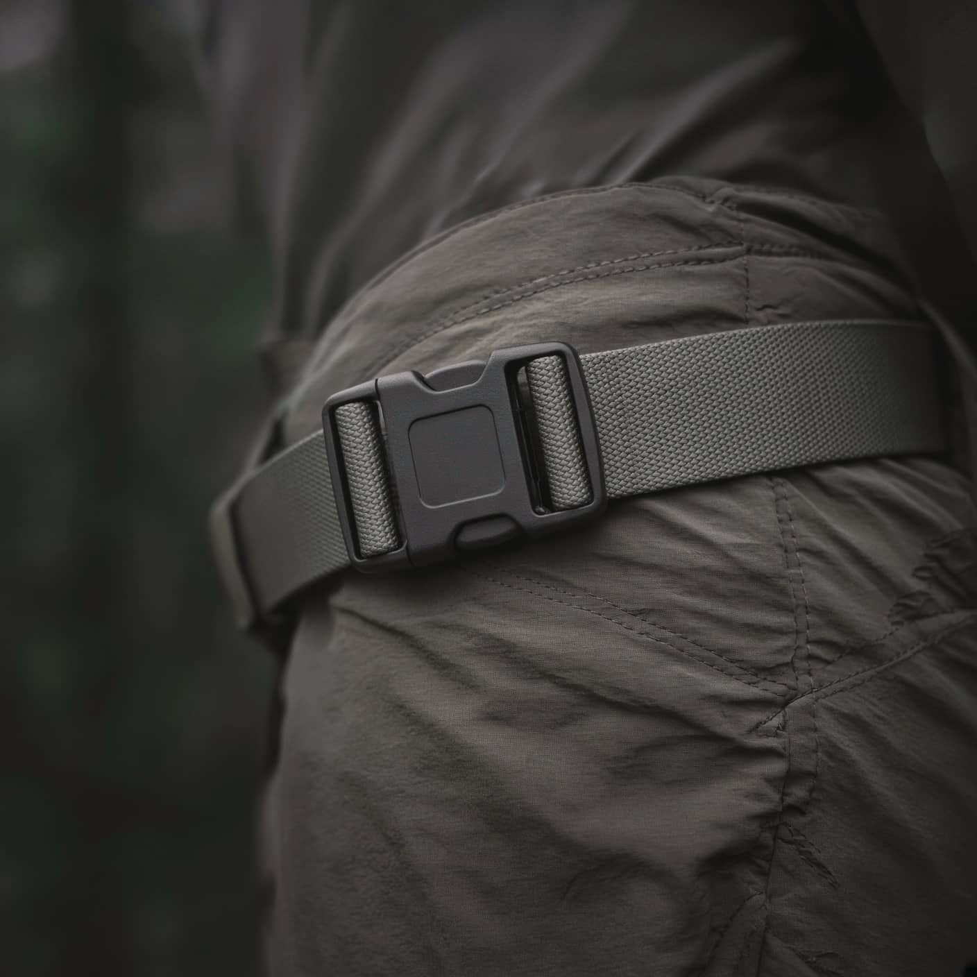 A hip-belt buckle cinched on the hips, close crop