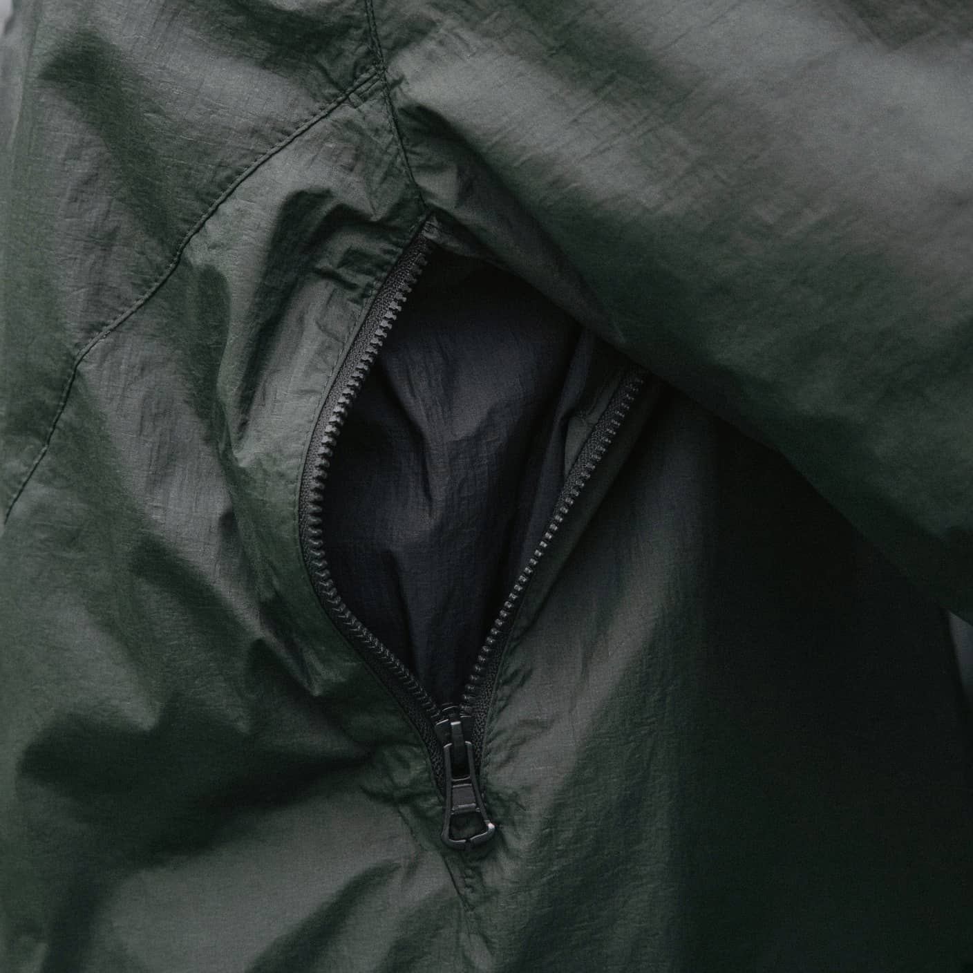An open underarm zip on a rain shell, close crop