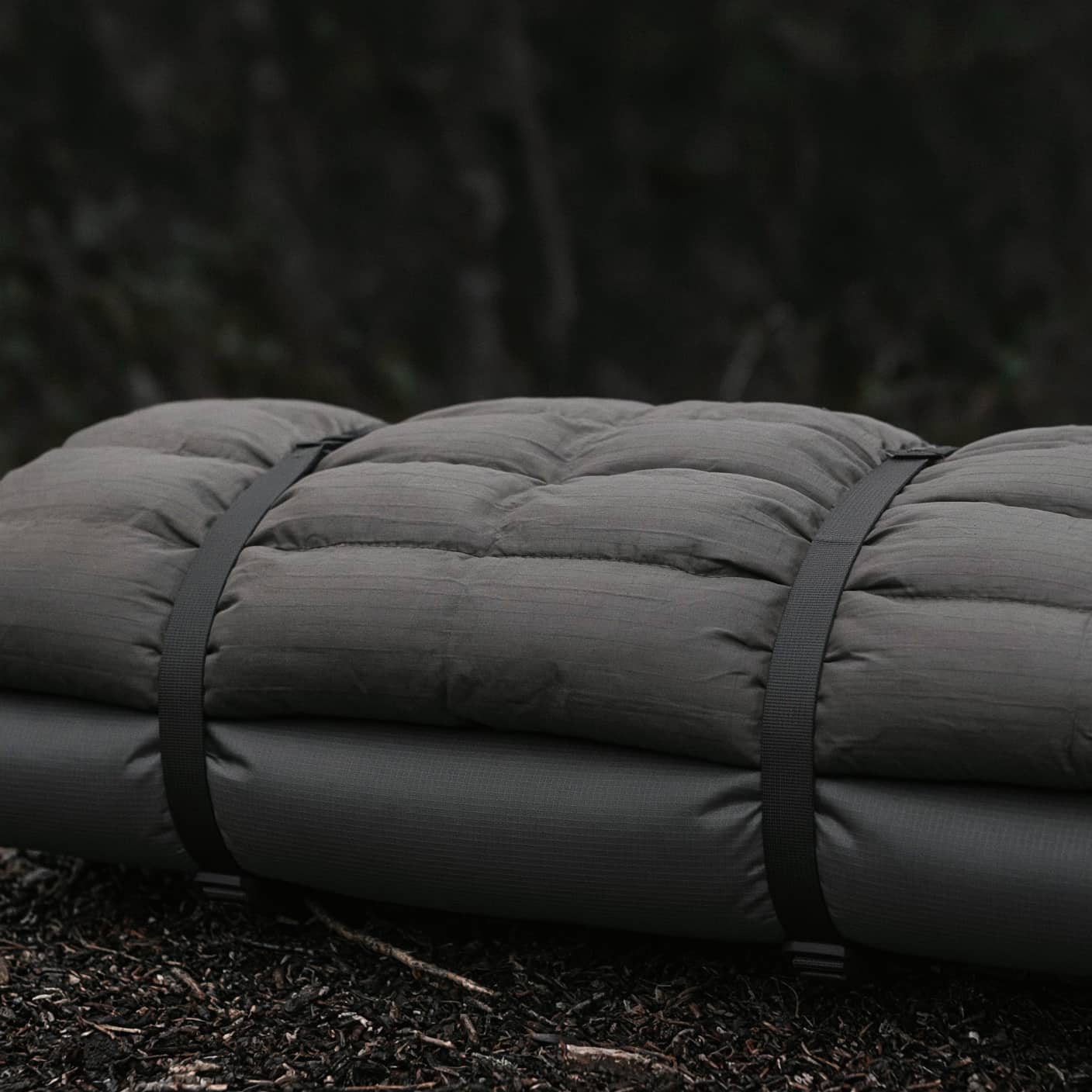 A quilt strapped down to a sleeping pad