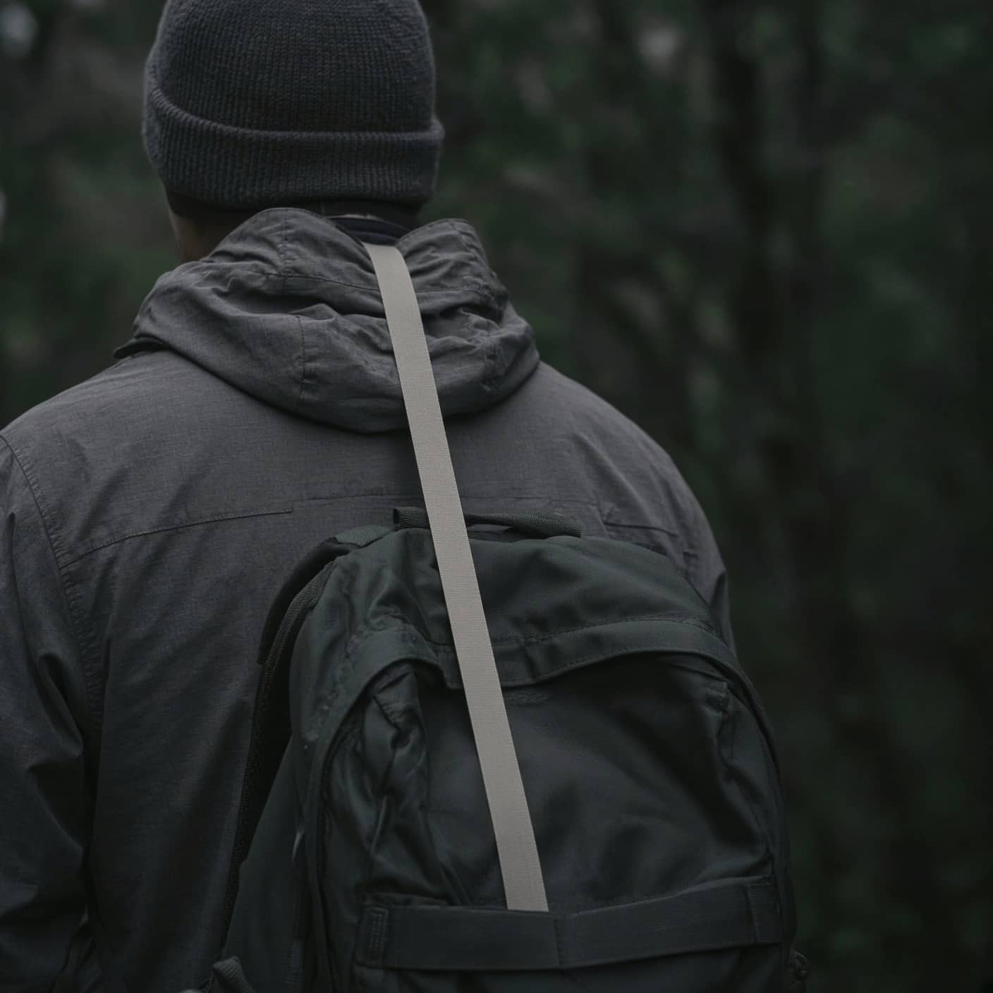 A soft tape measure along a hiker's spine, back view