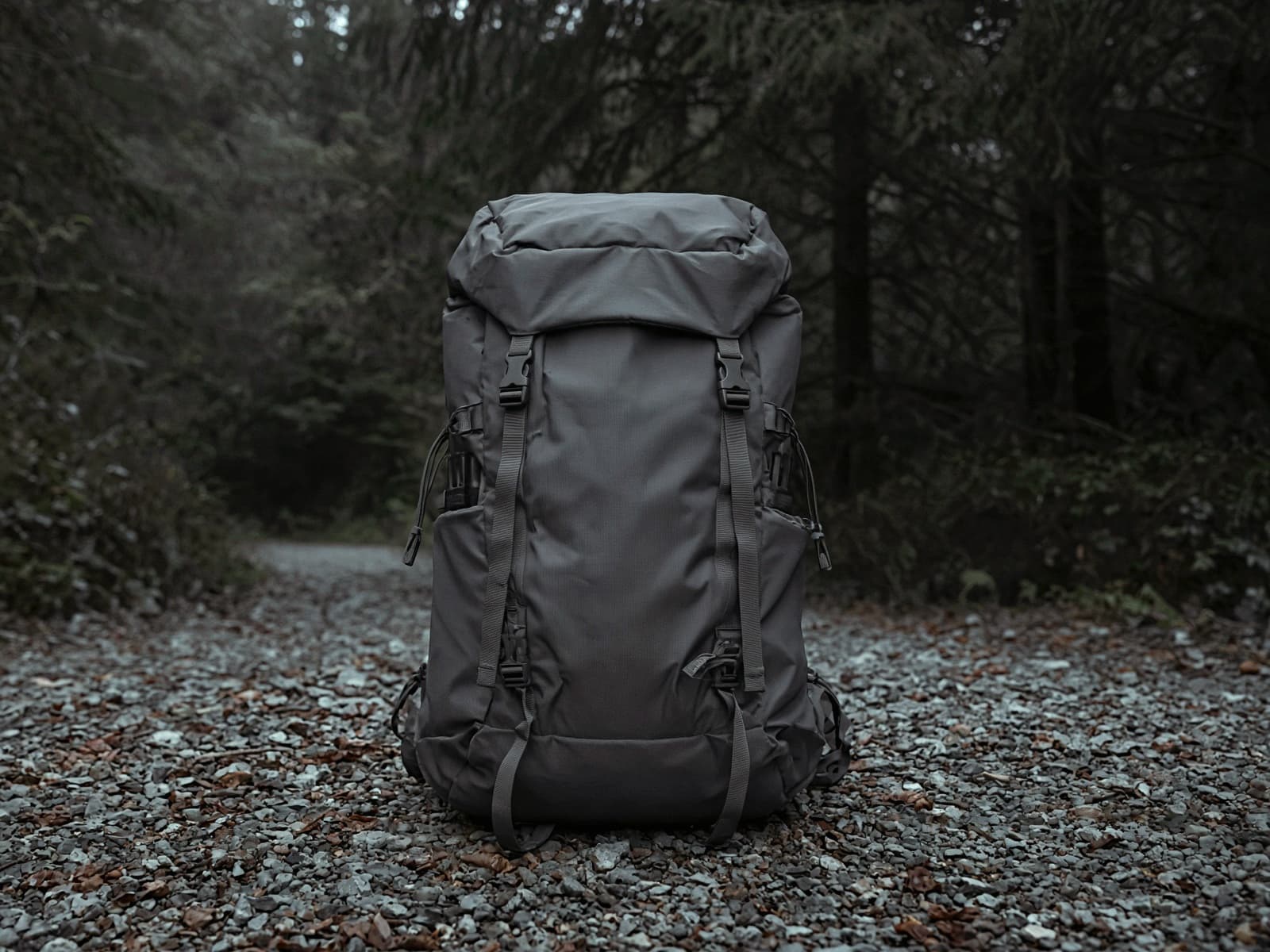 A framed ultralight 55-liter pack standing on trailhead gravel
