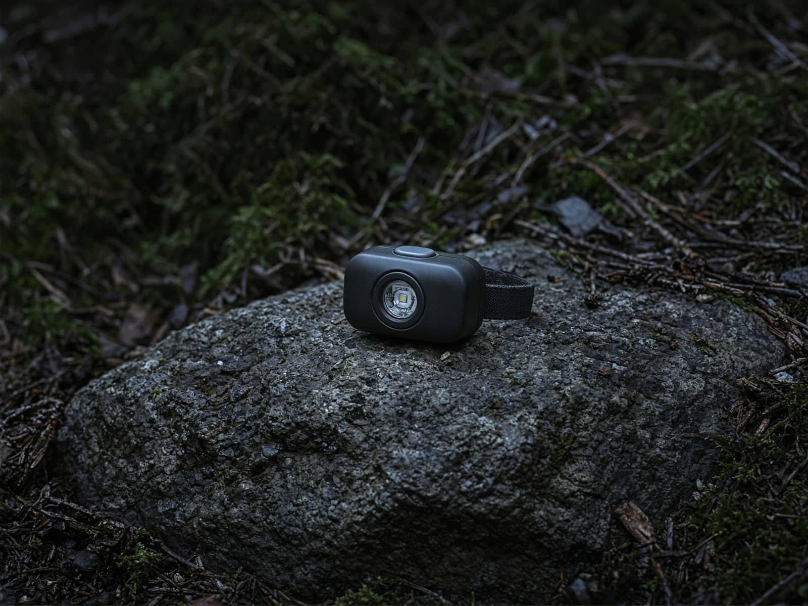 A tiny lightweight headlamp on a rock at blue hour