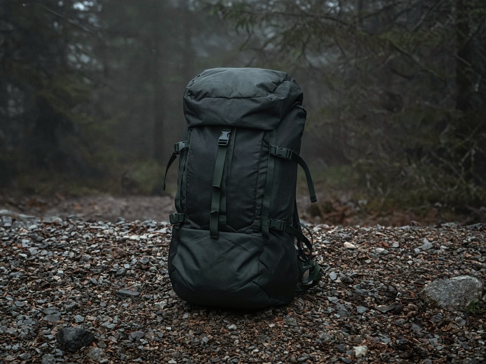 A 40-liter overnight pack standing on trailhead gravel
