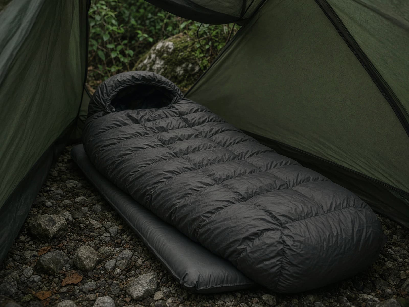 A small-packing ultralight down mummy lofted on a pad inside a tent