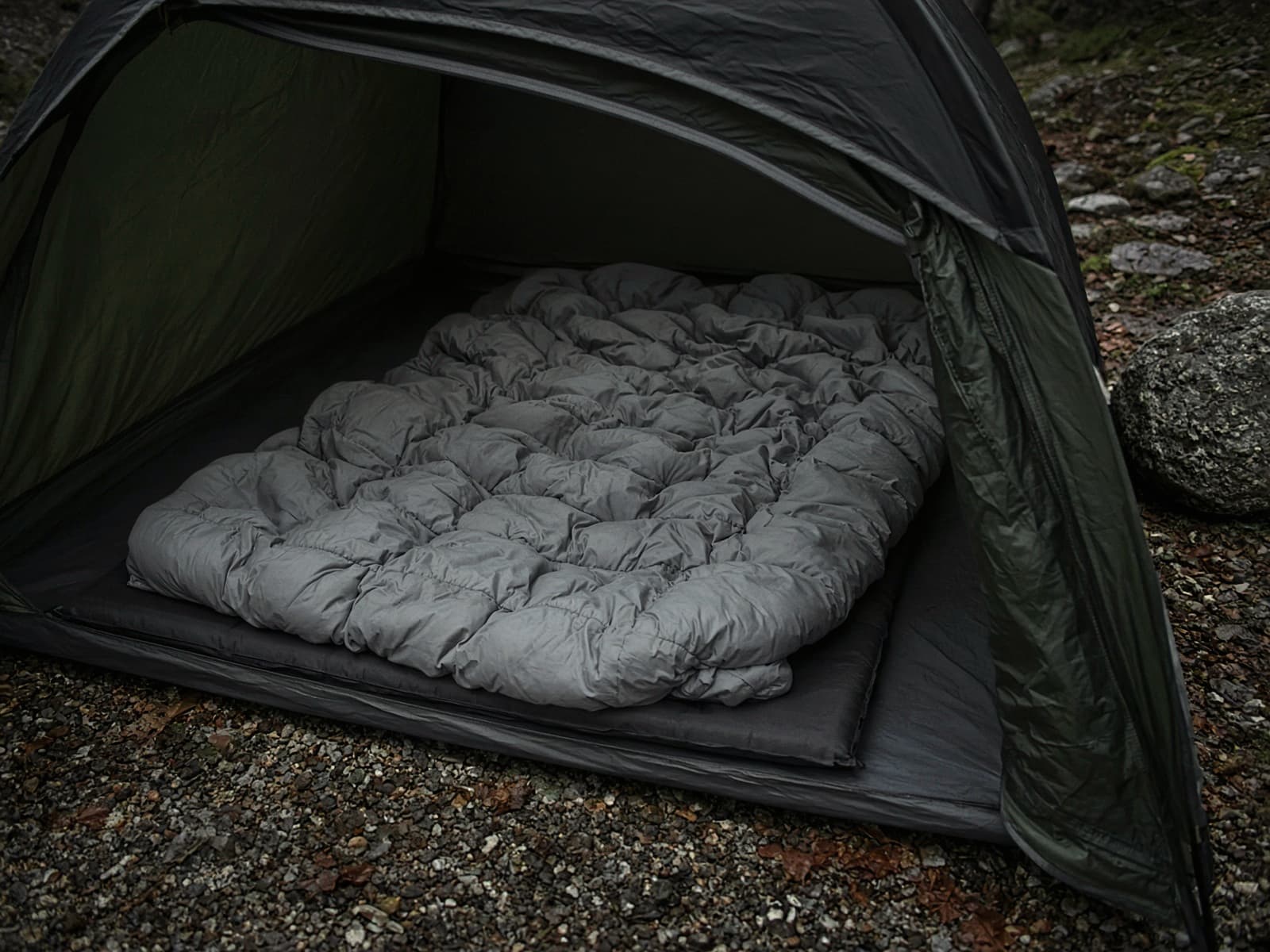 A budget down quilt lofted on a pad inside a tent