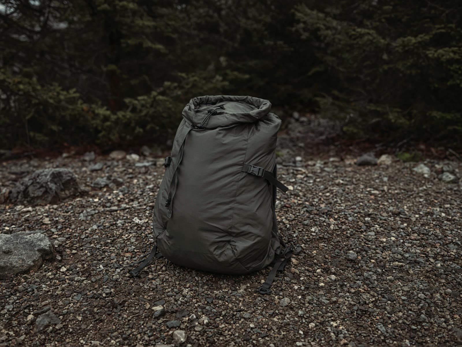 A simple framed ultralight pack standing on trailhead gravel