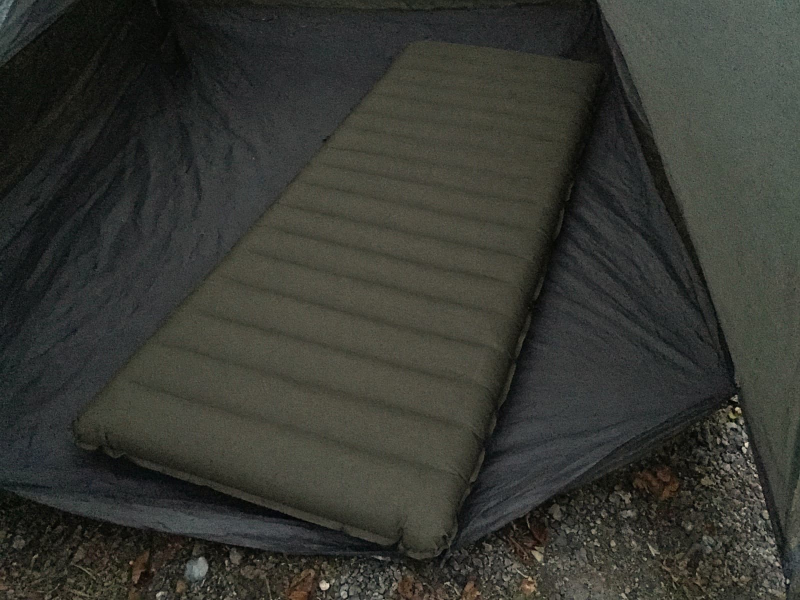A wide tapered air pad on a tent floor