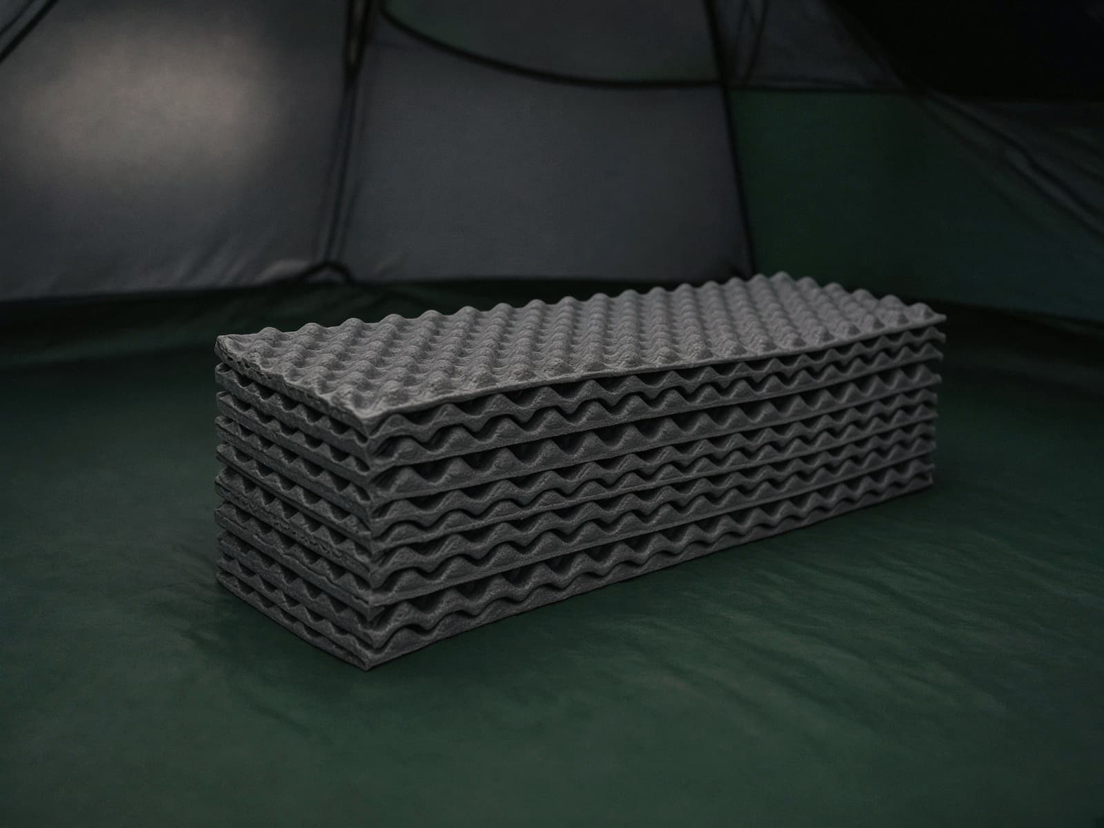 A folded accordion closed-cell foam pad on a tent floor